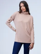 Polera color beige de tejido suave con cuello alto y mangas largas con aplique de botones.
