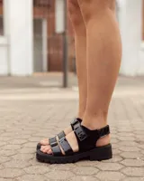 Sandalias Zenda de cuero negro con tiras delanteras de charol, ajuste con velcro y suela chunky de goma con plataforma.
