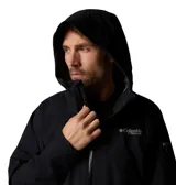 Campera impermeable Columbia de la línea Titanium, color negro, con capucha fija, cierre frontal revestido de PU, bolsillos laterales con cremallera y puños ajustables. Diseño técnico con costuras selladas y tecnología Omni-TECH.