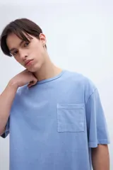 Remera color crudo de algodón con calce oversize, manga corta, cuello redondo y estampa en la espalda con texto en color negro.