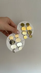 Aros colgantes con forma de discos de bronce y alpaca.