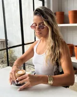 Lentes de sol hexagonales con marco dorado y lentes marrones.