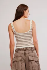 Musculosa acanalada de corte ajustado y corto, con estampado de rayas horizontales en tonos azules y rojos sobre base blanca. Presenta escote cuadrado con abertura frontal y tirantes anchos.
