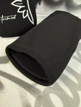 Par de rodilleras negras de neopreno de 7mm con logo de alas y nombre de la marca en color celeste.