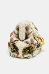 Bolso tipo pouch rígido, con cuerpo cubierto de abalorios, cuentas y apliques florales en tonos verdes, beige y dorados. Cuenta con cierre de botón imantado y cadena extraíble para usar como bandolera.