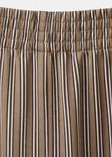 Pantalón de corte ancho, color tostado con sutiles rayas verticales en tonos marrones y oscuros, confeccionado en poliéster.
