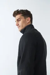 Buzo negro de tejido bondeado con medio cierre y logo en goma.