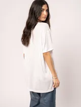 Remera blanca oversized de tela elastizada con tajos laterales y escote redondo.