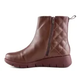 Bota corta de cuero negro con diseño matelassé en el lateral, plataforma baja y tirador trasero.