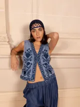 Chaleco de jean celeste con bordado floral monocromático en azul.