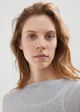 Poncho gris de punto con diseño asimétrico de capa, cuello barco y mangas tres cuartos.