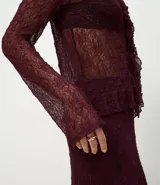 Blusa de encaje transparente color bordó, con mangas largas, escote en V con volados frontales y bajo fruncido.