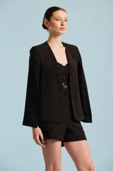 Capa de mujer color negro, con diseño envolvente y silueta estructurada, confeccionada por Karech para ocasiones especiales.
