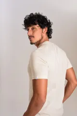 Remera de cuello redondo y manga corta color beige, con estampado gráfico frontal en color naranja que representa un brindis con diversas copas y el logo de la marca Original Penguin.