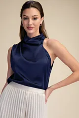 Top sin mangas de satén color azul marino, con diseño asimétrico y cuello tipo cowl drapeado.