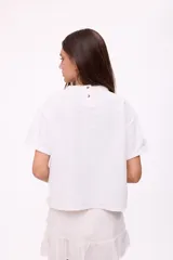 Remera blanca de algodón con cuello redondo y mangas cortas con dobladillo. Estampado pequeño en el pecho con logo de la marca y dibujo de frutas.