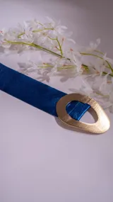 Cinto plateado con glitter y hebilla dorada con forma irregular.