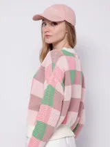 Sweater de tejido de punto con diseño jaquard a cuadros en tonos rosa y verde. Es de manga larga y cuello a la base.