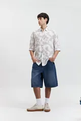 Camisa oversize de manga corta con estampado abstracto en tonos beige y blanco.