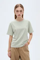 Remera blanca de manga corta, cuello redondo a la base y diseño holgado, confeccionada en algodón.