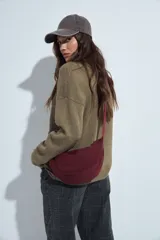 Sweater de punto gris con cuello a la base y diseño de trama geométrica en relieve. Presenta un calce relajado con mangas largas y puños tejidos.