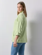 Camperita de mujer Ruby Rd. color verde lima con rayas blancas horizontales. Presenta cuello camisero, cierre frontal con botones metálicos a presión y bolsillos delanteros con solapa. Las mangas son largas y se pueden remangar.