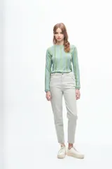 Pantalón tipo jean de corte recto y tiro medio, en color beige con sutiles rayas verticales en tonos tierra.