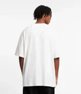 Remera blanca de algodón, corte oversized, manga corta y cuello redondo. Estampado frontal con la imagen de un rostro y la frase "Never Out O' Tune".