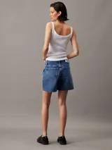 Short de jean estilo mom, de talle alto y lavado azul medio. Presenta un diseño clásico de cinco bolsillos, bragueta con cremallera y bajo con terminación deshilachada.