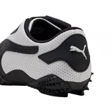 Championes Puma modelo Mostro Perforated, de diseño bajo con exterior de cuero perforado en color blanco y detalles en negro. Presenta una suela distintiva con relieve de tachones y cierre de velcro en el empeine.