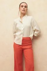 Pantalón de lino color verde, de tiro alto, con bolsillos en el frente y atrás, y corte recto.