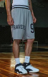 Bermuda deportiva gris con cintura elástica de rayas negras y grises. Estampado frontal con la palabra "RAVERS" y el número "90" en tipografía universitaria negra con borde blanco.