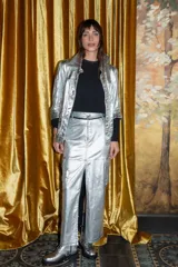 Falda midi plateada metalizada con tajo frontal, bolsillos cargo con solapa, cierre y botón metálico.