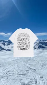 Remera blanca de corte holgado con estampado gráfico en color negro en la espalda, con motivos de esquí, montaña y elementos de viaje.