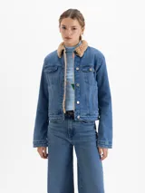 Campera de jean tipo trucker con interior de corderito sintético, cierre frontal con botones metálicos y bolsillos en el pecho.