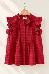 Blusa de diseño cuadrillé en color rojo y blanco, sin mangas, con volados en el cuello mao y en los hombros. Cuenta con alforzas verticales en el frente y cierre frontal de botones.