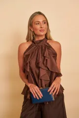 Blusa de organza color marrón con diseño halter, cuello alto atado atrás y abundantes volados en el frente.