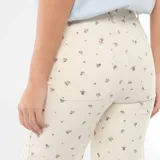 Pantalón de corte wide leg en color crudo con estampado floral pequeño, tiro alto, bolsillos frontales y cierre con botón y cremallera.