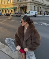 Chaqueta corta de pelo sintético color marrón, con cuello amplio y mangas abullonadas.