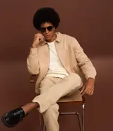 Campera masculina de estilo casual con cuello inglés, cierre frontal por cremallera, bolsillos laterales y ajuste elástico en el bajo. Presenta detalles de recortes en la parte superior delantera.