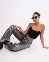 Corset negro de corte recto con escote asimétrico, confeccionado en tela elastizada con cierre en la espalda.