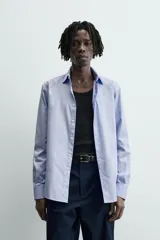 Camisa slim fit de algodón color celeste, con cuello italiano y manga larga con puños abotonados. Cierre frontal de botonadura.