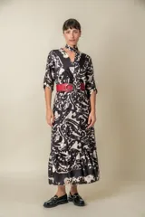 Vestido midi italiano cruzado, confeccionado en satén de seda estampado en blanco y negro. Tiene cintura elastizada con lazo y mangas tres cuartos con presilla.