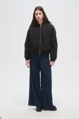 Campera bomber negra con cuello de piel sintética marrón, cierre frontal con cremallera y puños elásticos.