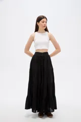 Falda larga de color negro con diseño de volados horizontales y cierre frontal de botones.