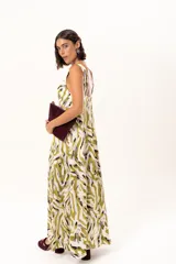 Vestido largo de tela sedosa con estampado abstracto en tonos verde oliva, blanco y negro. Presenta escote en V profundo, tirantes anchos y tajos laterales pronunciados en la falda.
