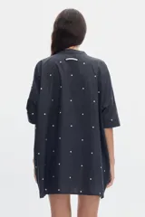 Vestido corto de algodón con estampa de lunares, cuello mao y cierre frontal con botones. Presenta un diseño holgado de mangas cortas.