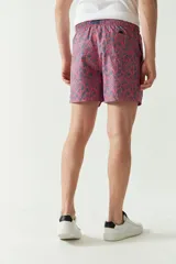 Short de baño con estampado botánico en tonos azules y rosados, con cintura elástica ajustable mediante cordón, bolsillos laterales y bolsillo trasero.