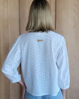 Camisa de jean celeste con cuello redondo, mangas abullonadas y puños elásticos. Cierre frontal con botones.