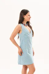 Vestido corto celeste con estampado de cuadros, de silueta recta y sin mangas, con escote en V profundo y recortes en diagonal.